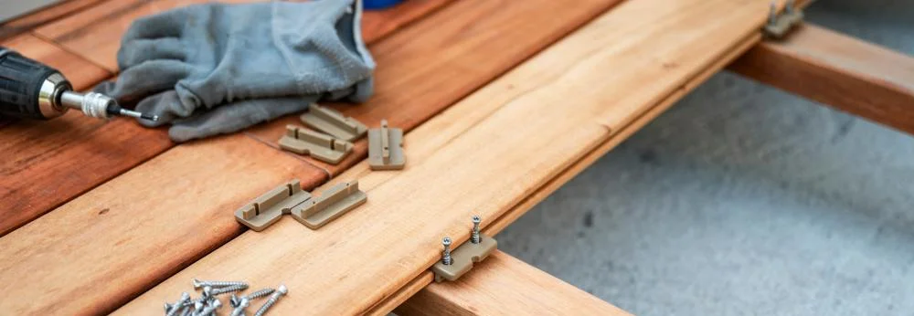 Holzdielen werden mit Clips auf einer Unterkonstruktion befestigt.